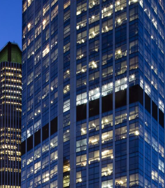 Lit skyscrapers against evening sky.