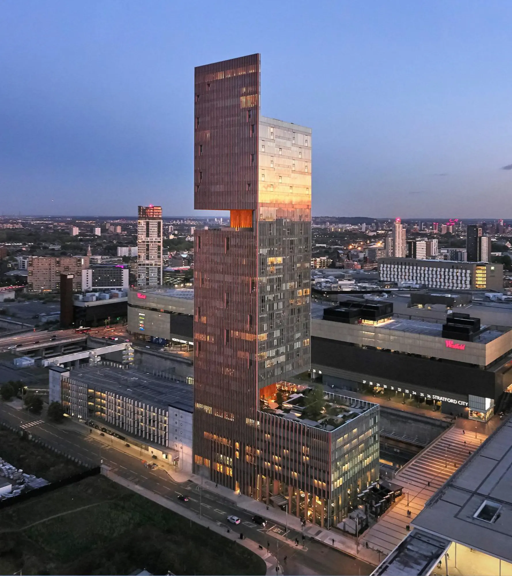 Tall modern skyscraper at sunset skyline.