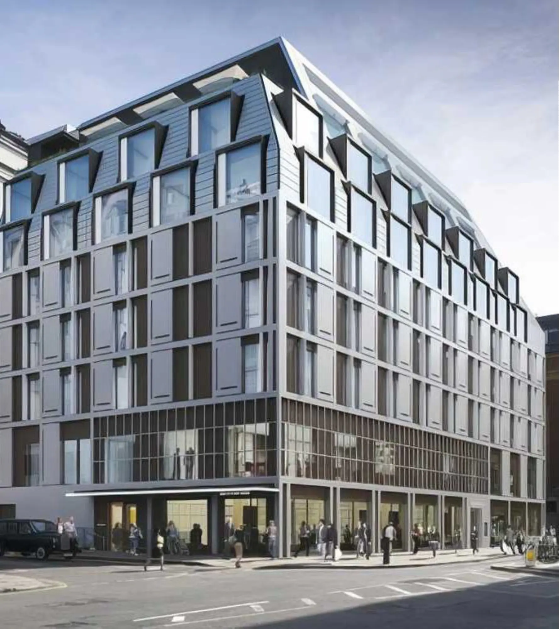 Modern glass building on a busy street.
