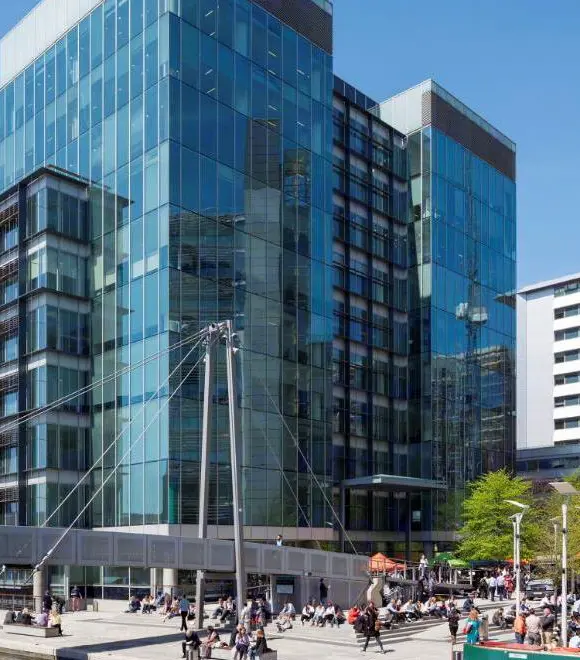 Modern glass office building with people outside.