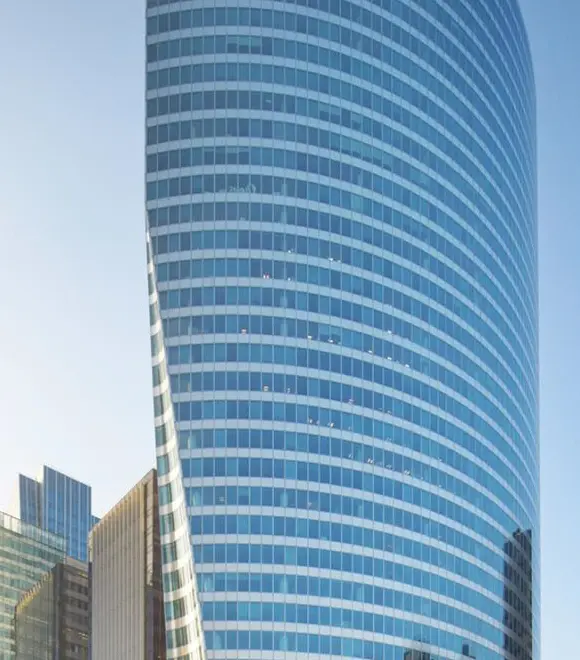 Curved glass skyscraper against clear sky.