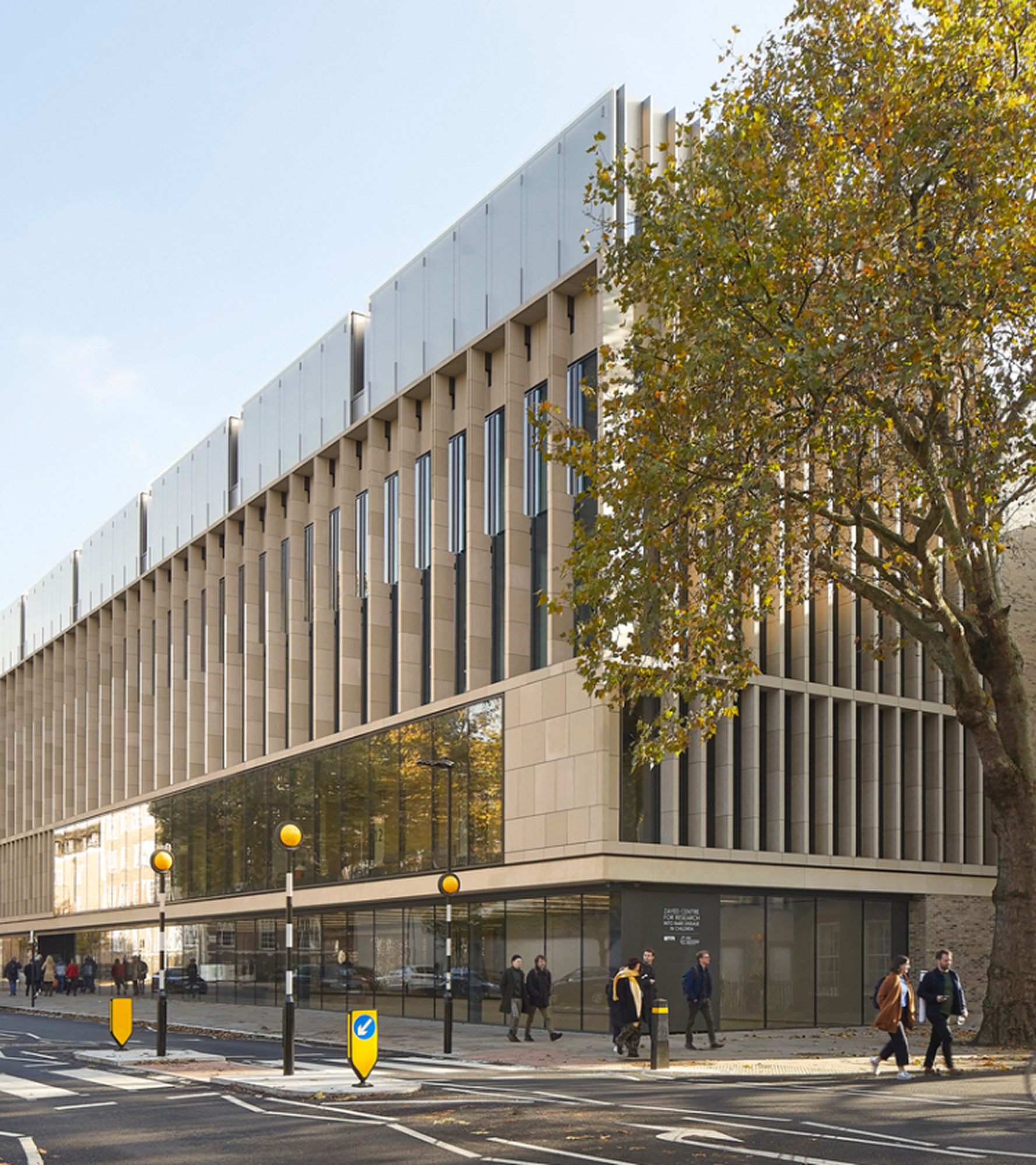 Modern concrete building with vertical windows and trees outside.