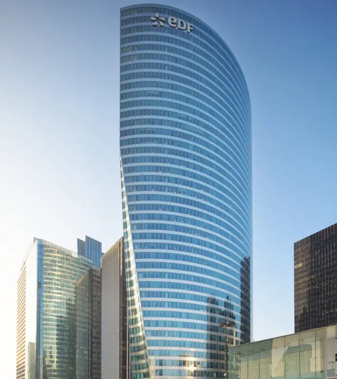 A sleek, modern skyscraper with a curved glass facade under a clear blue sky.