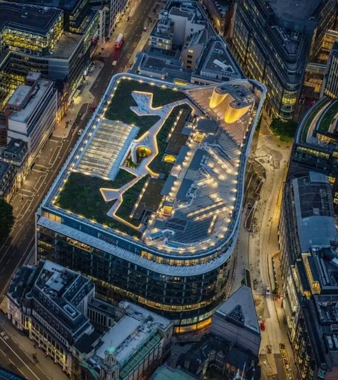 Aerial view of a modern building with a rooftop garden and geometric patterns.