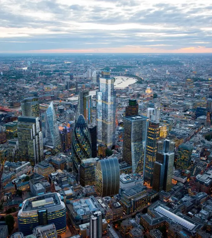 Aerial view of a bustling cityscape with modern skyscrapers at sunset.